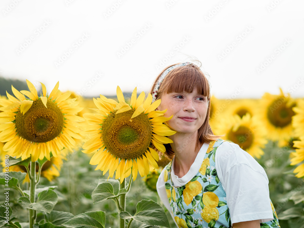A girl stands in a field with yellow sunflowers A girl stands in a field with yellow sunflowers