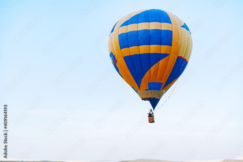 Naklejka premium Multicolored air balloon in clear blue sky