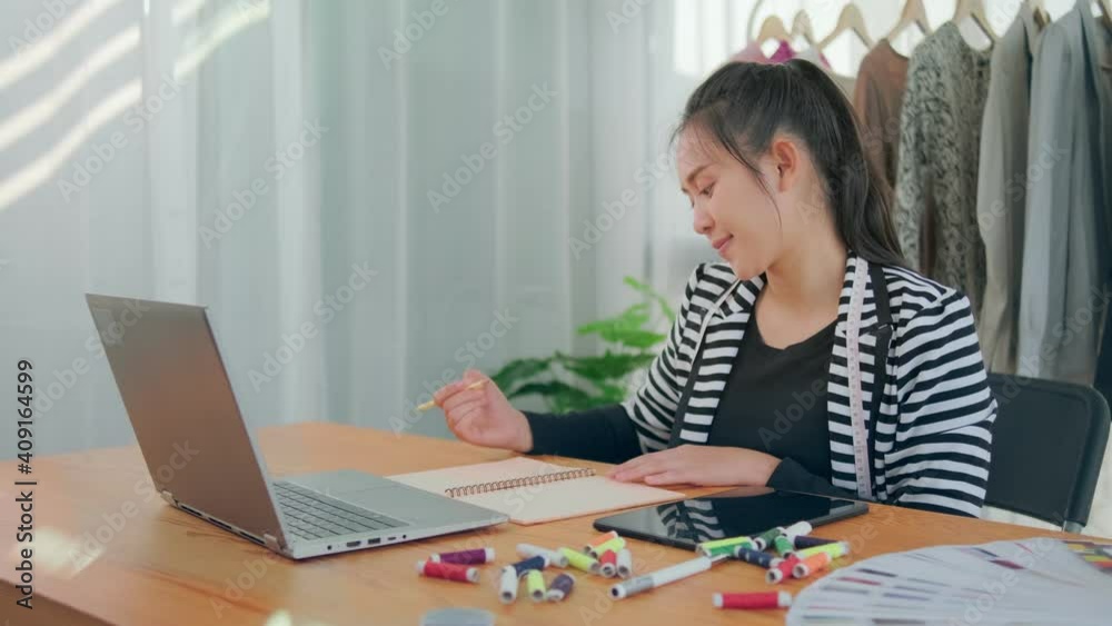 Happy smiling Successful small business Asian woman study writing on note book using digital laptop device technology online research internet sales marketing planning fashion, home modern office. Happy smiling Successful small business Asian woman study writing on note book using digital laptop device technology online research internet sales marketing planning fashion, home modern office.