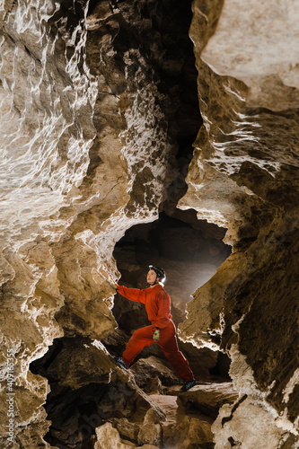 A portrait of a young female caver exploring the cave