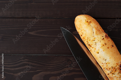 Baguette bread on brown wooden board close up