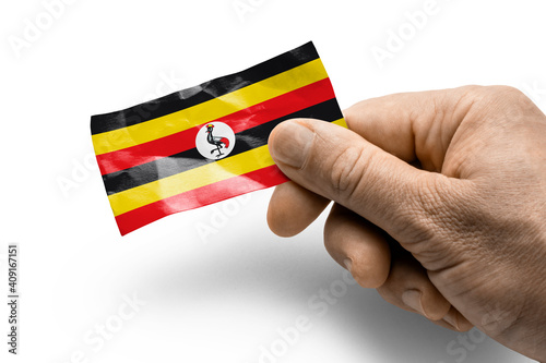 Hand holding a card with a national flag the Uganda