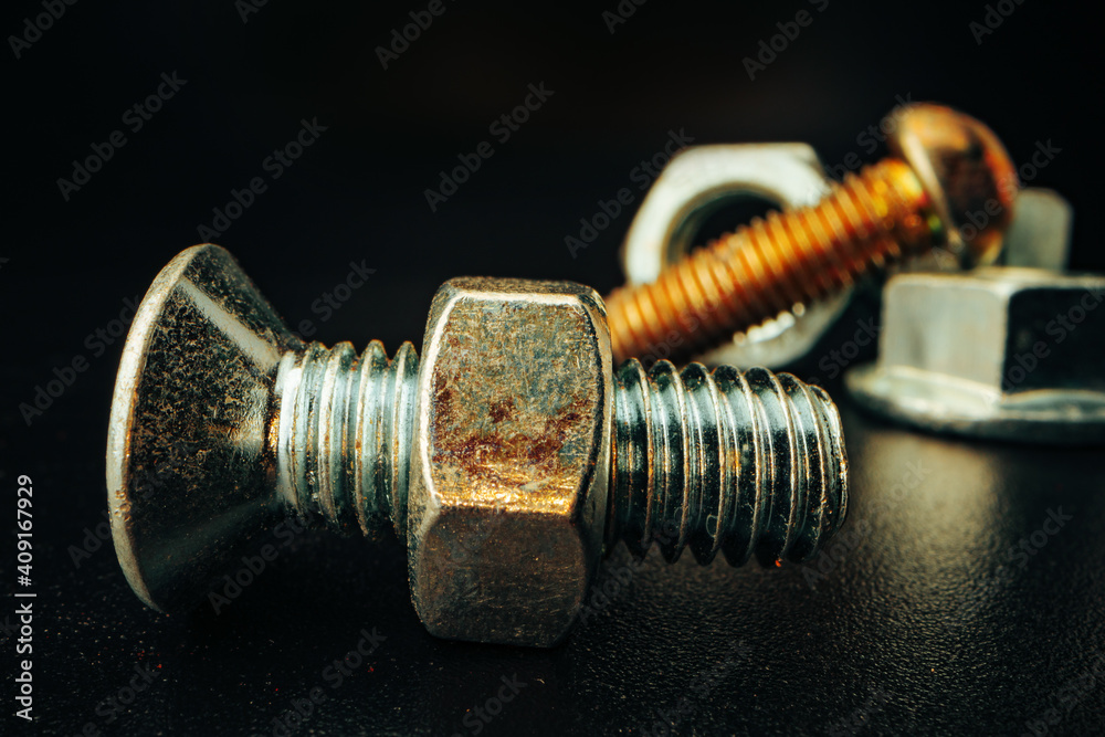 Metal screws and nuts on black background Metal screws and nuts on black background