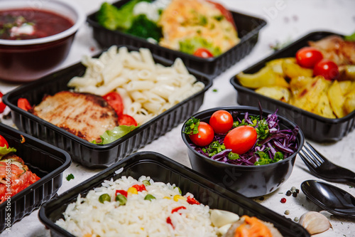 Lunch boxes  dishes in disposable plastic dishes  Russian cuisine - borsch  soup  rice  vegetables  pasta  meat cutlets  mushrooms. Top view