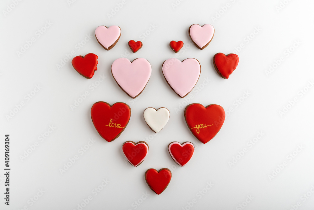 Many heart-shaped cookies with color sugar icing. White background, top view. Valentines day treat.