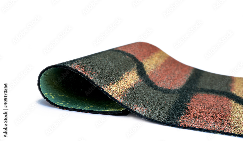 Dark green, yellow, and orange shingle roof on white background. Roofing material. Shingle roof texture. Shingle roof made from asphalt, plastic fiberglass. Rough unique pattern granules surface. Dark green, yellow, and orange shingle roof on white background. Roofing material. Shingle roof texture. Shingle roof made from asphalt, plastic fiberglass. Rough unique pattern granules surface.