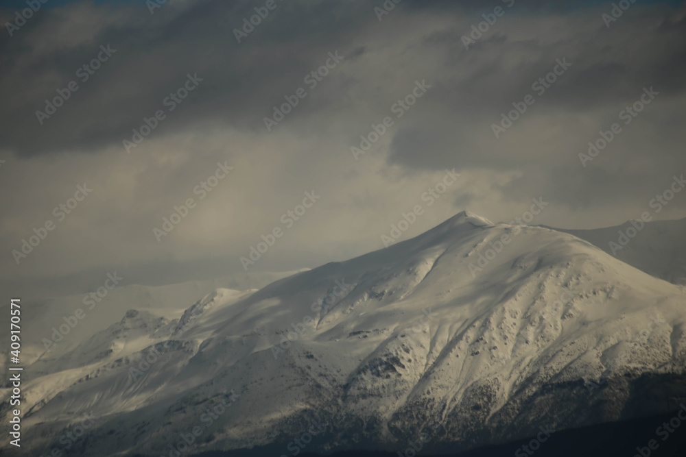 mountain pick with snow on top clouds ice winter background in mitsikeli mountain grreece