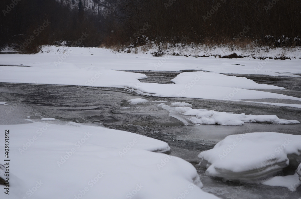 mountain river in wintertime. carpathian landscape with spruce forest and snow covered shore ukraine mountain river in wintertime. carpathian landscape with spruce forest and snow covered shore ukraine