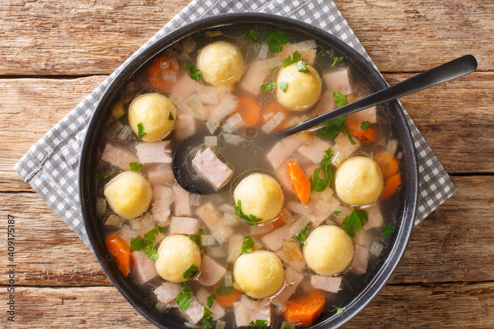 Delicious Liechtenstein cuisine soup with ham and cornmeal dumplings close-up in a plate on the table. horizontal top view from above Delicious Liechtenstein cuisine soup with ham and cornmeal dumplings close-up in a plate on the table. horizontal top view from above