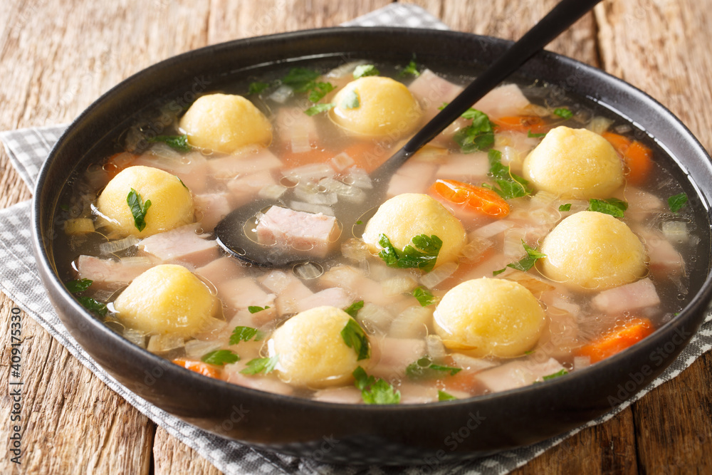 Hafalaab soup with ham, vegetables and cornmeal dumplings close-up in a plate on the table. horizontal Hafalaab soup with ham, vegetables and cornmeal dumplings close-up in a plate on the table. horizontal