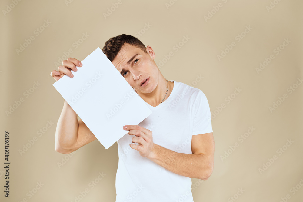 man in white t-shirt sheet of paper in hands Copy Space cropped view beige background man in white t-shirt sheet of paper in hands Copy Space cropped view beige background