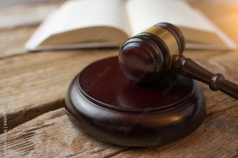 Court and justice. Judge's hammer on a wooden table against the background of books, constitution