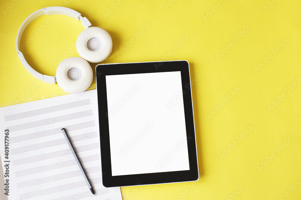 Top view open music book, headphones and a pen on a yellow background. mock up for music lessons Top view open music book, headphones and a pen on a yellow background. mock up for music lessons