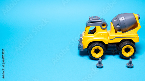 The toy car is a designer on a blue background. The wheels of the typewriter are spinning. Toy tire mount for a toy store or children's development center © Zarina Lukash
