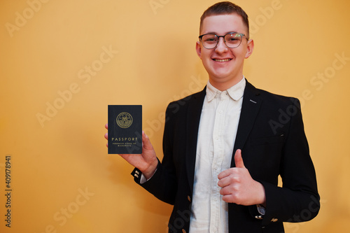 Young handsome man holding Federated States of Micronesia passport id over yellow background, happy and show thumb up.  Travel to Oceania country concept. photo