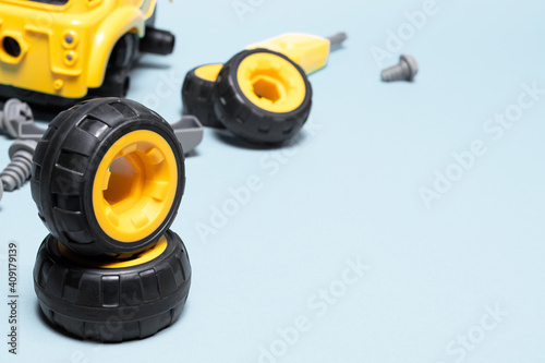 Wheels of the designer's toy car on a light background with space for text. © Zarina Lukash