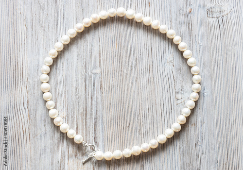 natural white pearl necklace on gray wooden background