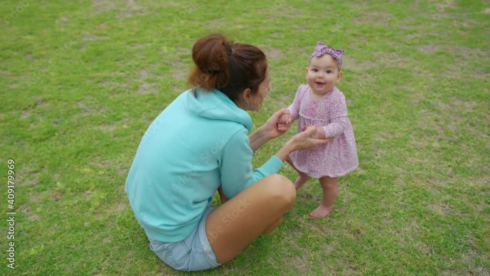 Happy little baby girl playing together with her mother outdoor in the park adorable baby lifestyle. Happy little baby girl playing together with her mother outdoor in the park adorable baby lifestyle.