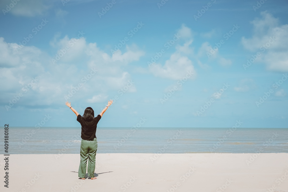 Happy woman raise hand up at tropical beach with blue sky background. Travel vacation and freedom feel good concept. Happy woman raise hand up at tropical beach with blue sky background. Travel vacation and freedom feel good concept.