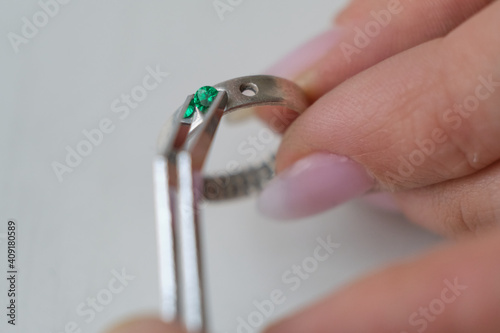 Macro shot. Craft jewelery making. Ring repairing. Putting the diamond on the ring. Desktop for craft jewellery making with professional tools. photo