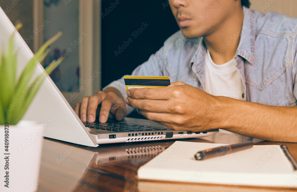 Zoom Hand of Asian Casual Businessman in Denim or Jeans Shirt Using Credit Card and Laptop for Online Payment in Coffee Shop. Casual Businessman with Technology in Vintage Tone Zoom Hand of Asian Casual Businessman in Denim or Jeans Shirt Using Credit Card and Laptop for Online Payment in Coffee Shop. Casual Businessman with Technology in Vintage Tone