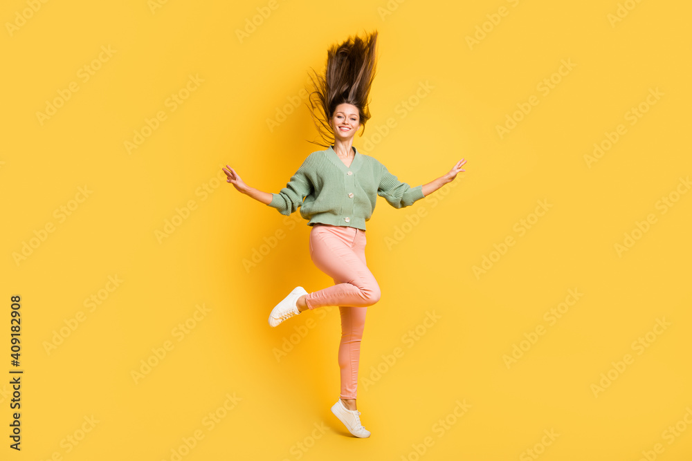 Full size photo of young lovely good looking smiling cheerful positive girl with flying hair isolated on yellow color background Full size photo of young lovely good looking smiling cheerful positive girl with flying hair isolated on yellow color background