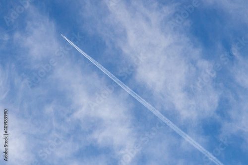 High white cirrus clouds with cirrostratus in a light blue sky with chaimtrails, sometimes called chair tails, indicate nice weather, but stormy changes occur within a few days. White clouds in a blue