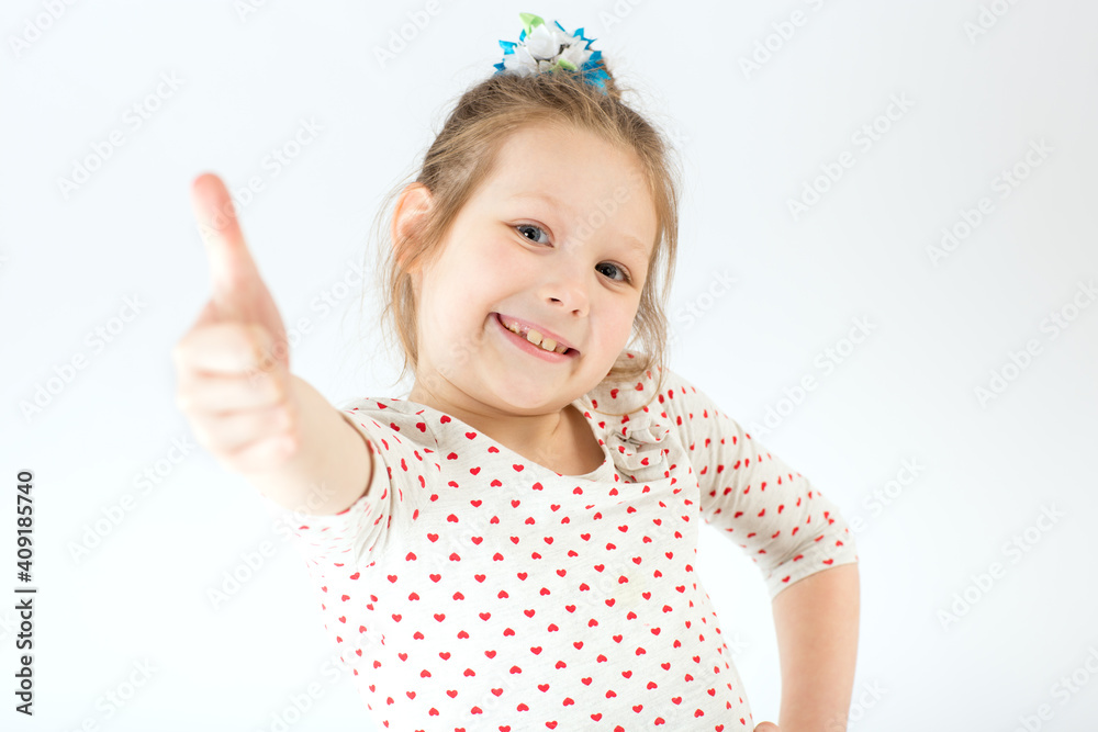 The girl stretches out her hand and shows her thumb up. The girl stretches out her hand and shows her thumb up.