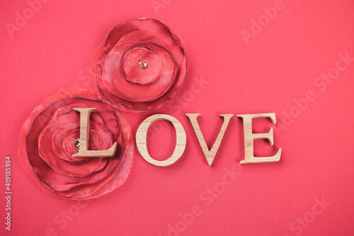 Love wooden font with red fabric rose flower on fabric background, valentine concept background idea, vintage tone style