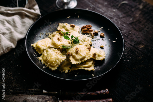 Ravioli with spinach, ricotta and parmesan on a black plate