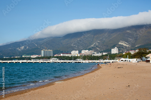 An empty beach in the city against the backdrop of mountains