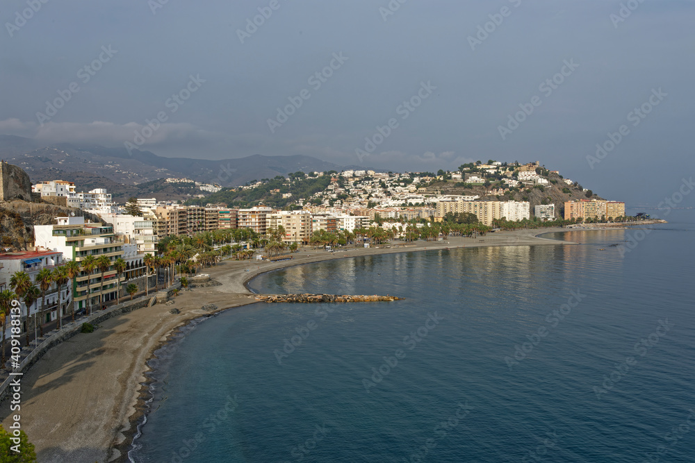 An empty Beach in the late Afternoon at the Spanish Coastal town of Almunica, with haze building over the Mountains.