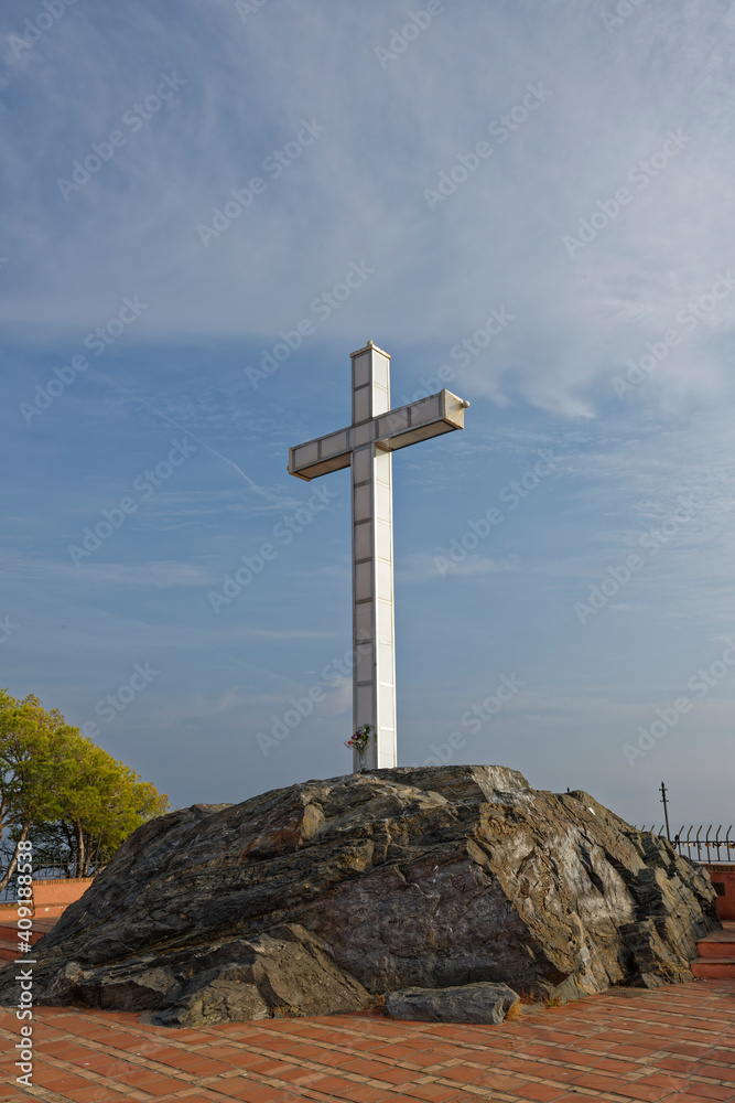 The metal cross Monument of the headland of the small Coastal Town of Almunica, on a late bright afternoon in September. The metal cross Monument of the headland of the small Coastal Town of Almunica, on a late bright afternoon in September.