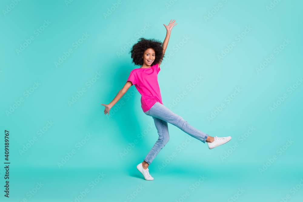 Full length photo portrait of dancing black skin girl standing on one leg isolated on vivid cyan colored background