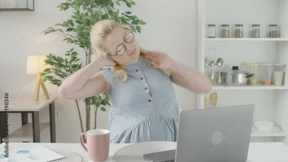 Expecting office worker stretching neck muscles, working on laptop, health Expecting office worker stretching neck muscles, working on laptop, health