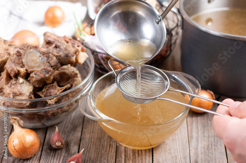 Photos Passing the bone broth through a sieve