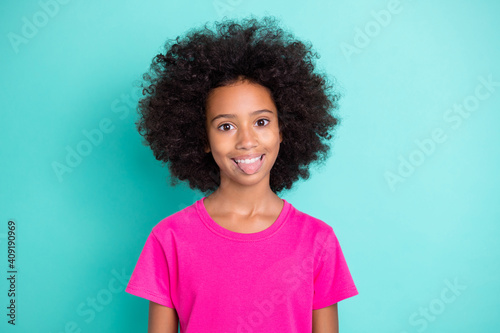 Photo portrait of funny afro american girl showing tongue isolated on vivid cyan colored background © deagreez