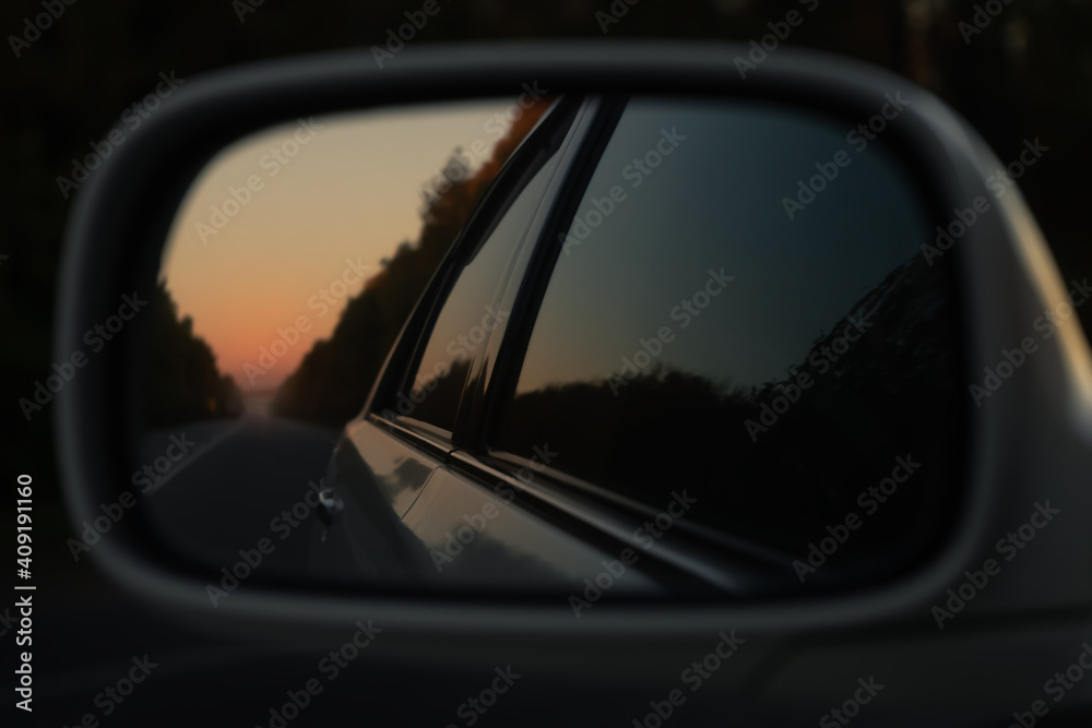 Sunset in the rearview mirror of the car
