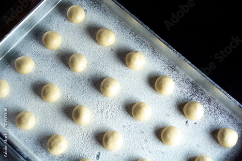 pattern of donnut dough on bake sheet with white flour photo