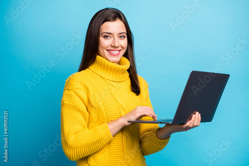 Profile side view portrait of lovely cheery girl holding in hands laptop watching lesson isolated over bright blue color background