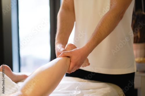 Relaxing massage on the foot in spa salon indoors.