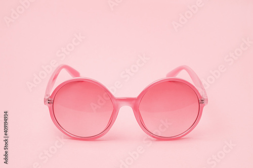Pink glasses on a pink background close-up in the center of the frame for Valentine's Day.
