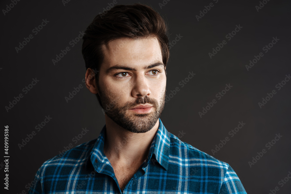 Brunette handsome unshaven guy posing and looking aside