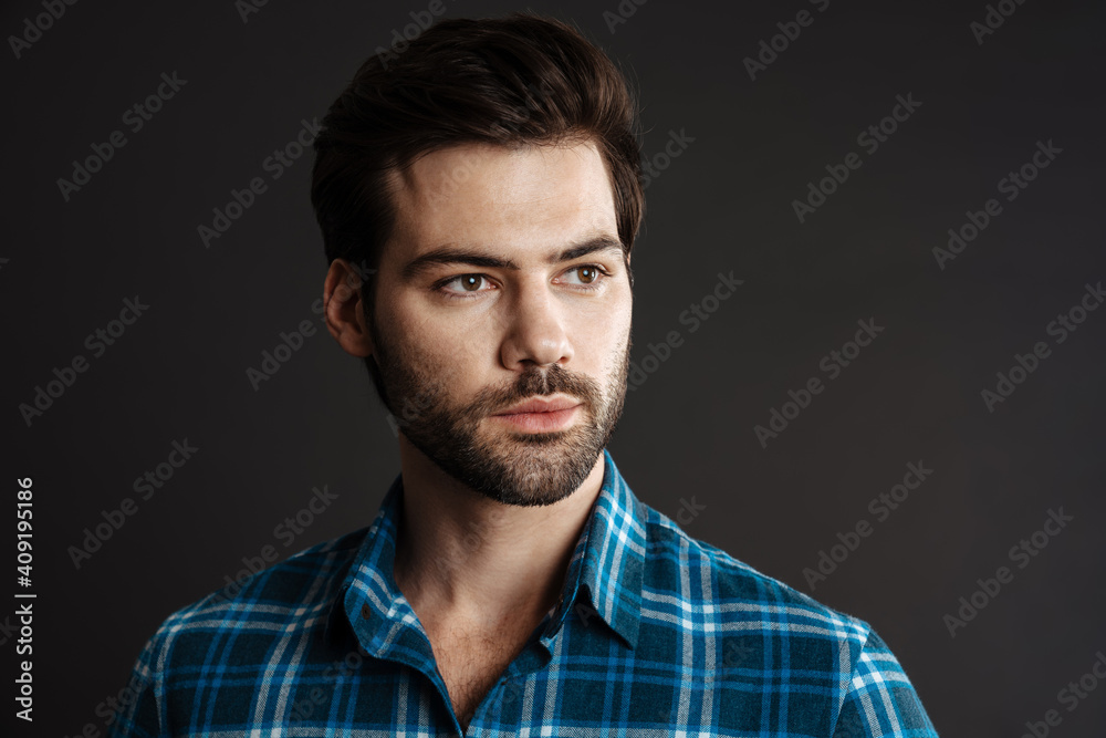 Brunette handsome unshaven guy posing and looking aside Brunette handsome unshaven guy posing and looking aside