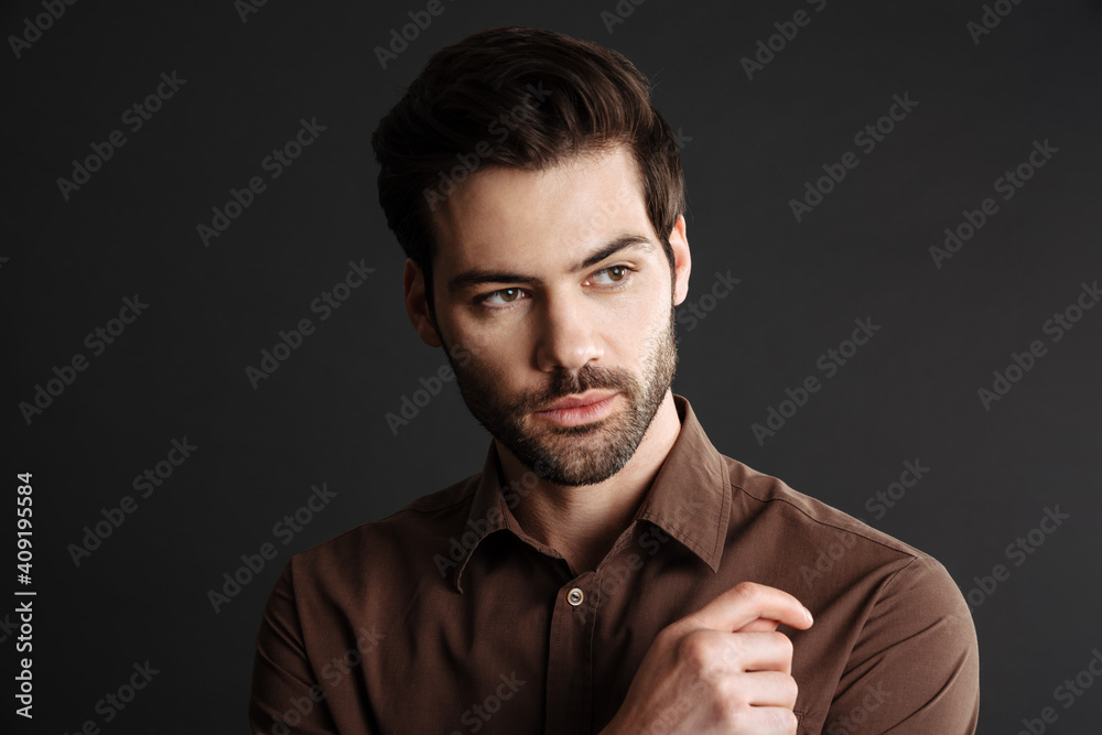 Fototapeta premium Brunette handsome unshaven guy posing and looking aside