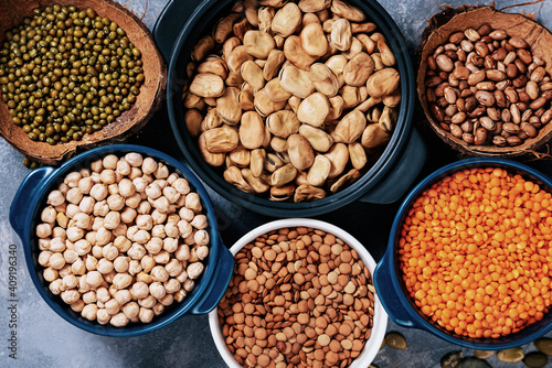Various assortment of legumes beans, chickpeas, lentils, green peas. Healthy eating concept. Vegetable proteins. concrete background copy space top view