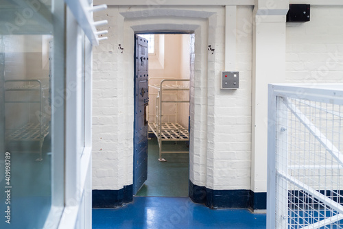 Fotografia Looking into prison cell block victorian British English jail house with bed in