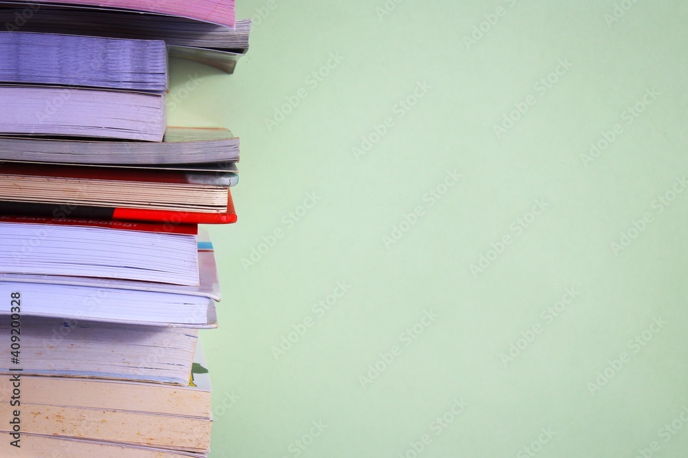 Stack of books on green background with copy space for text Stack of books on green background with copy space for text