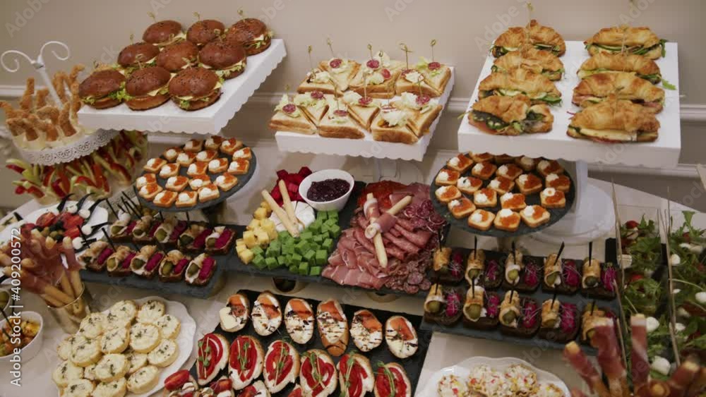 Table with variety of Canapes: traditional snacks or appetizers for parties, events, and cocktails, served before the main meal at formal receptions. With bread as base and different toppings on top Table with variety of Canapes: traditional snacks or appetizers for parties, events, and cocktails, served before the main meal at formal receptions. With bread as base and different toppings on top
