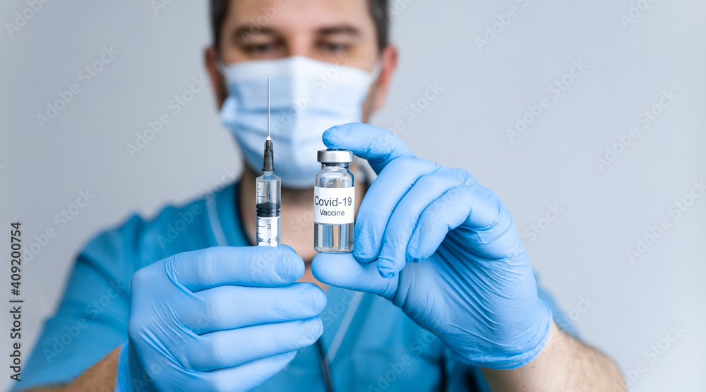 Doctor in rubber gloves holding coronavirus COVID-19 vaccine in vial and syringe. Healthcare And Medical concept. Close up Doctor in rubber gloves holding coronavirus COVID-19 vaccine in vial and syringe. Healthcare And Medical concept. Close up